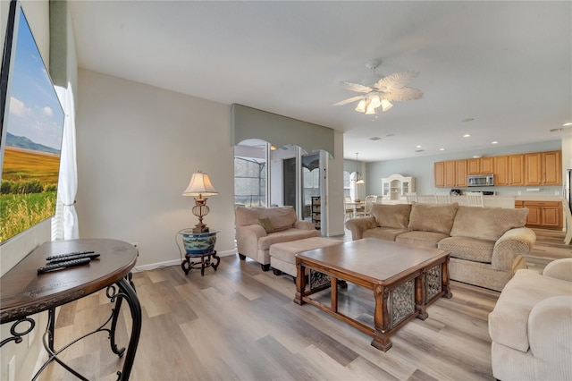 living room with ceiling fan and light hardwood / wood-style flooring