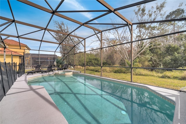 view of pool with an in ground hot tub, glass enclosure, and a patio