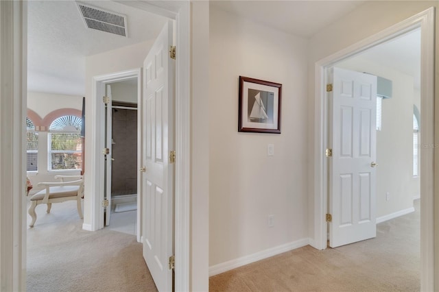 hallway with light colored carpet