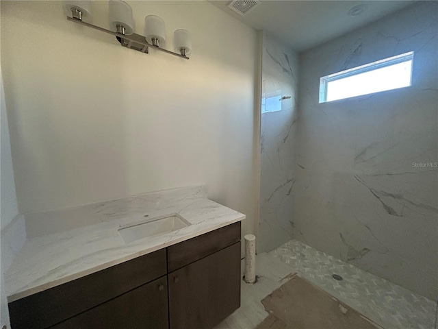 bathroom featuring vanity and a tile shower