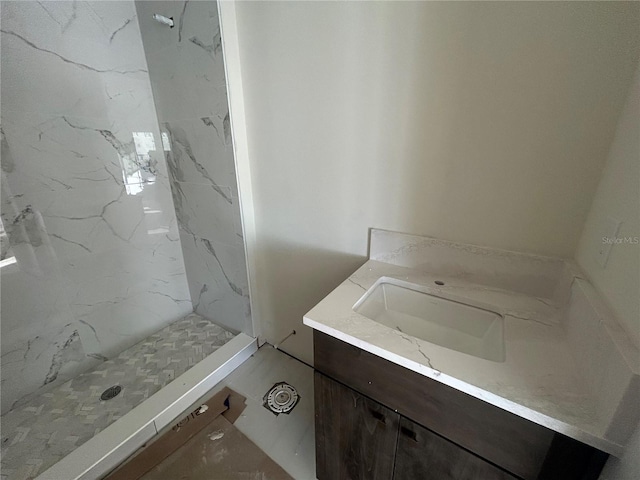 bathroom featuring tiled shower and vanity