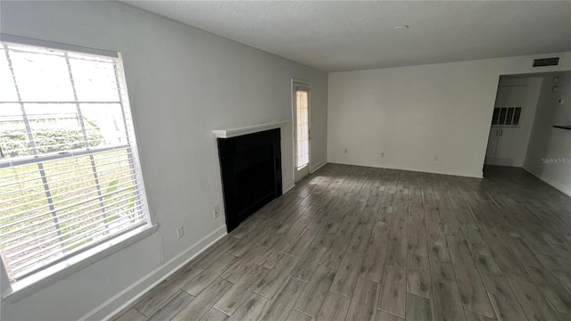 unfurnished living room with a textured ceiling and hardwood / wood-style flooring