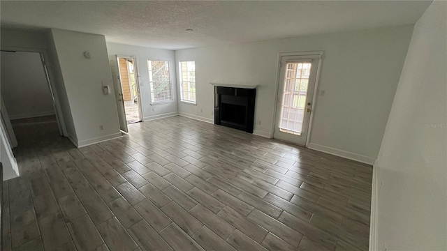 unfurnished living room with plenty of natural light and a textured ceiling