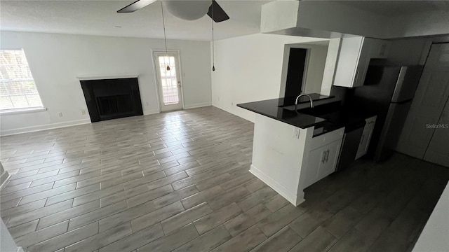 kitchen featuring kitchen peninsula, refrigerator, ceiling fan, decorative light fixtures, and white cabinets