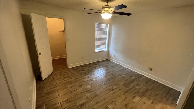 unfurnished bedroom featuring a walk in closet, ceiling fan, and dark hardwood / wood-style floors