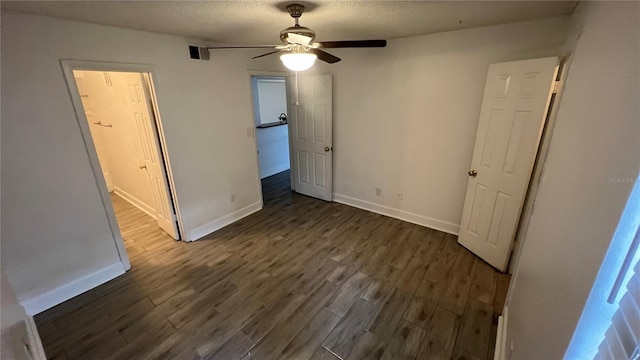 unfurnished bedroom featuring a textured ceiling, dark hardwood / wood-style floors, and ceiling fan