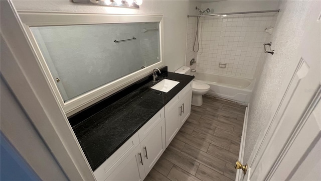 full bathroom featuring vanity, toilet, and tiled shower / bath