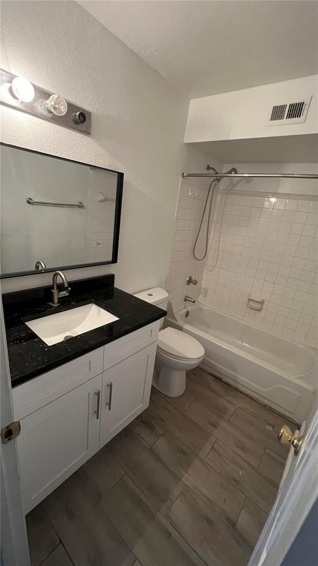 full bathroom with tiled shower / bath combo, toilet, and vanity