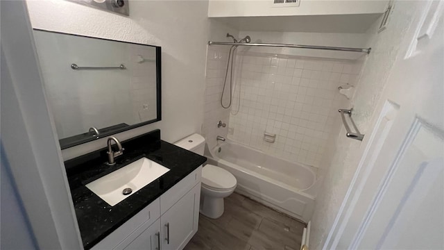 full bathroom featuring tiled shower / bath, hardwood / wood-style floors, vanity, and toilet