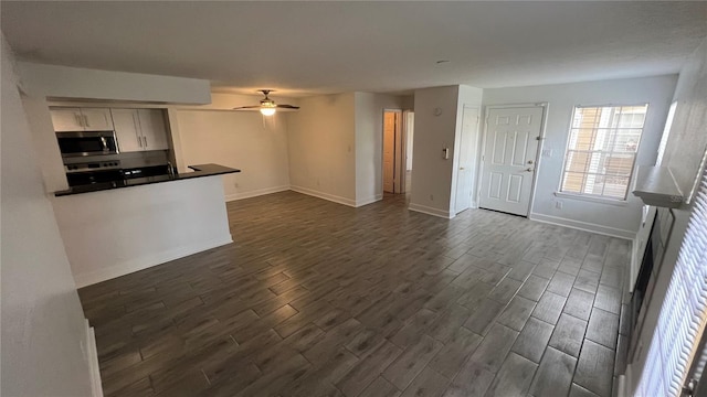 5587 Devonbriar Way Unit 104, Orlando, FL 32822 - kitchen with stainless steel microwave, dark wood finished floors, a ceiling fan, and open floor plan