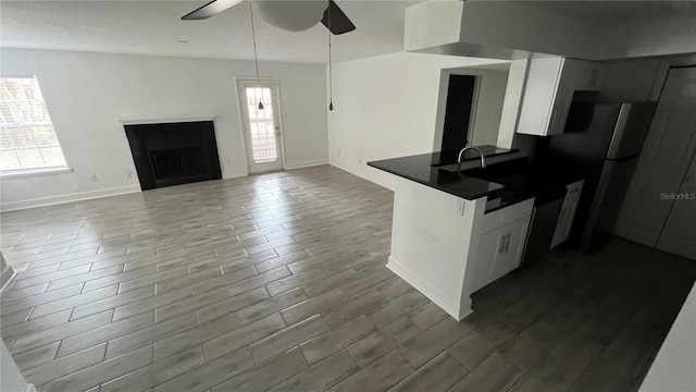 5587 Devonbriar Way Unit 104, Orlando, FL 32822 - kitchen with dark countertops, ceiling fan, freestanding refrigerator, and white cabinetry