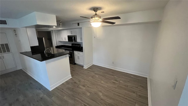5587 Devonbriar Way Unit 104, Orlando, FL 32822 - kitchen with appliances with stainless steel finishes, dark countertops, a peninsula, ceiling fan, and white cabinetry