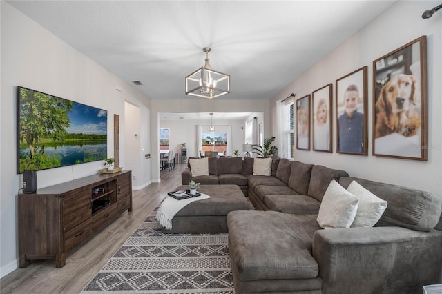 living room with a chandelier and light hardwood / wood-style floors