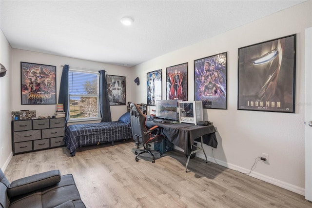 bedroom with a textured ceiling and light wood-type flooring