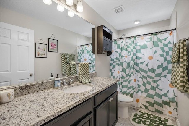 bathroom featuring tile patterned floors, vanity, toilet, and walk in shower