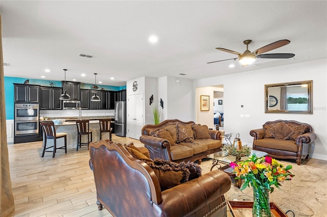 living room featuring ceiling fan and light wood-type flooring