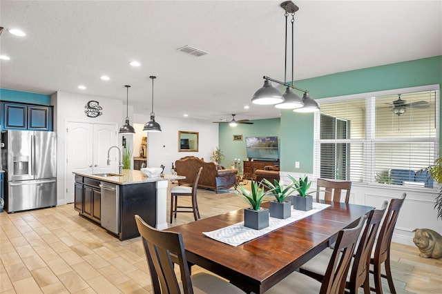 dining area with ceiling fan and sink