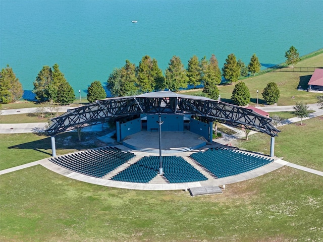 view of swimming pool with a water view and a lawn