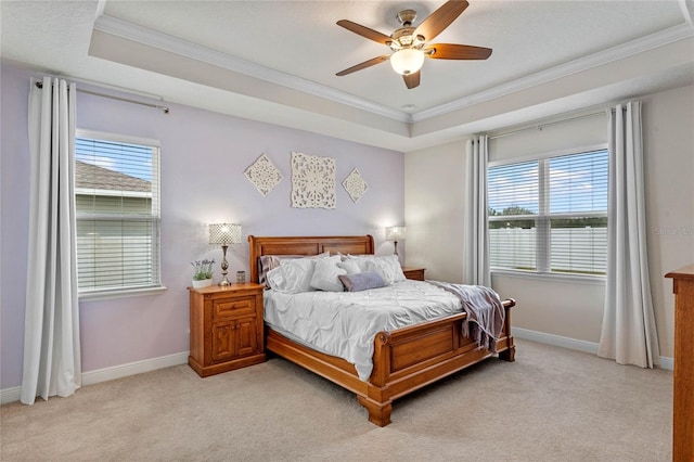 carpeted bedroom featuring ornamental molding, ceiling fan, and a tray ceiling