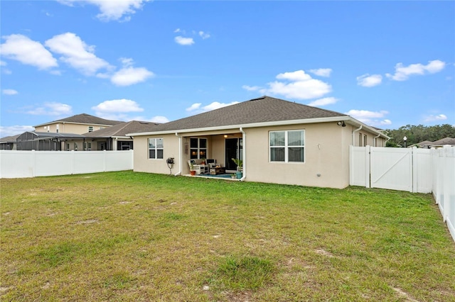 back of house with a patio and a yard