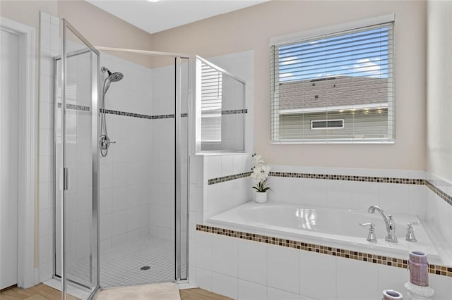 bathroom featuring shower with separate bathtub