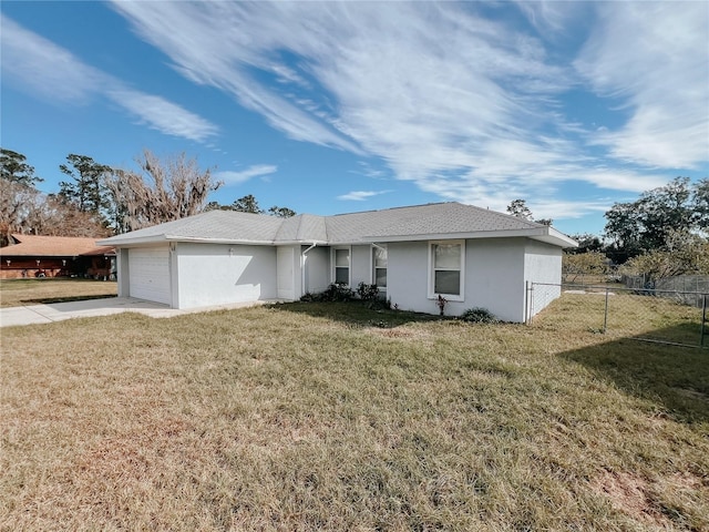 ranch-style house featuring a garage and a front lawn