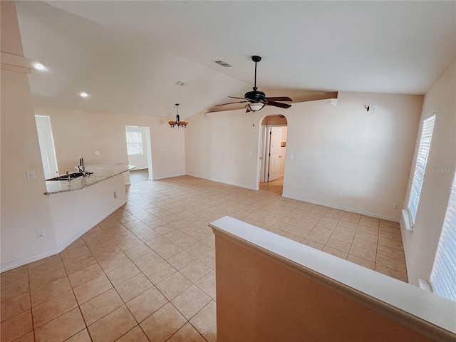 unfurnished living room featuring light tile patterned floors, ceiling fan, lofted ceiling, and sink