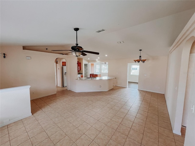 unfurnished living room featuring light tile patterned floors, vaulted ceiling, ceiling fan, and sink