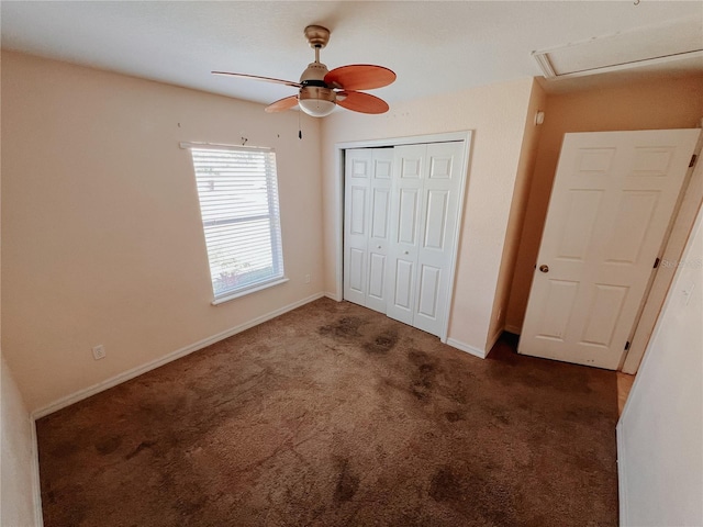 unfurnished bedroom with dark colored carpet, a closet, and ceiling fan