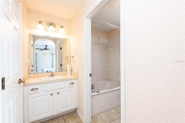 bathroom featuring tile patterned flooring, ceiling fan, a bathing tub, and vanity