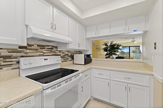 kitchen with white appliances, backsplash, white cabinets, ceiling fan, and light tile patterned floors