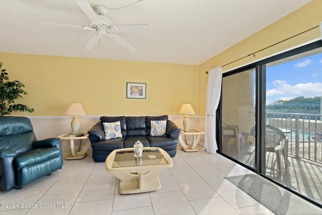 tiled living room with ceiling fan and a textured ceiling