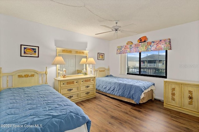 bedroom with hardwood / wood-style flooring, ceiling fan, and a textured ceiling