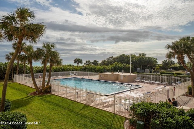 view of swimming pool featuring a lawn and a patio