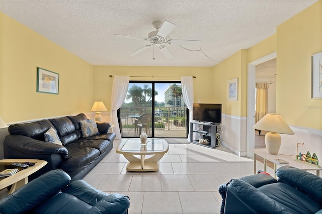7520 Ridgewood Ave Unit 205, Cape Canaveral, FL 32920 - tiled living room featuring a textured ceiling, a wainscoted wall, and ceiling fan