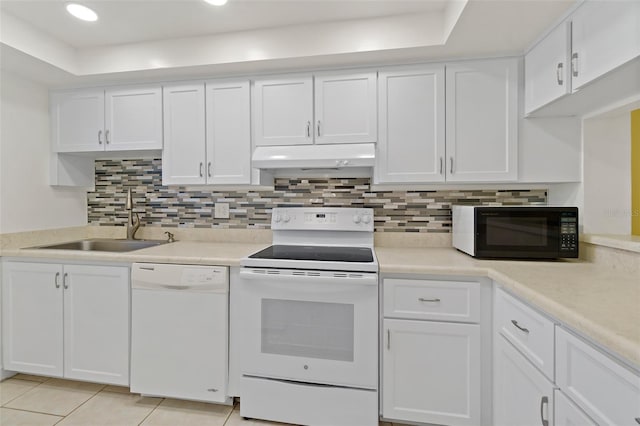 7520 Ridgewood Ave Unit 205, Cape Canaveral, FL 32920 - kitchen featuring white appliances, white cabinetry, under cabinet range hood, light countertops, and a sink