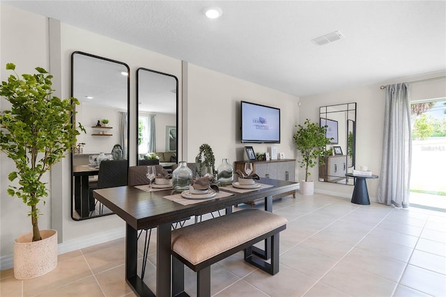 dining room featuring light tile patterned floors and a textured ceiling