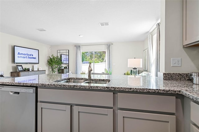 kitchen featuring gray cabinetry, dishwasher, light stone countertops, and sink