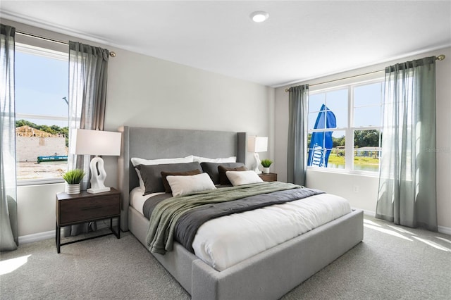 bedroom with light colored carpet and multiple windows