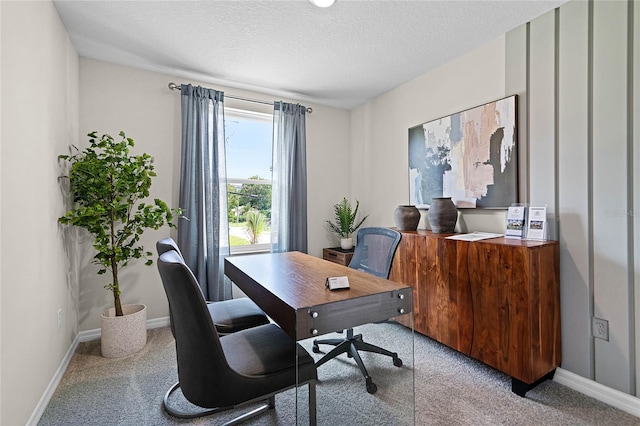 carpeted office space featuring a textured ceiling