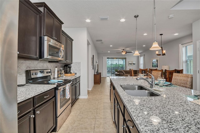 kitchen featuring ceiling fan, sink, hanging light fixtures, backsplash, and appliances with stainless steel finishes