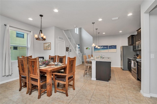 tiled dining space featuring sink and a notable chandelier