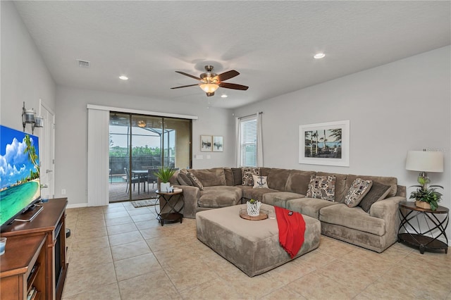 tiled living room with a textured ceiling and ceiling fan