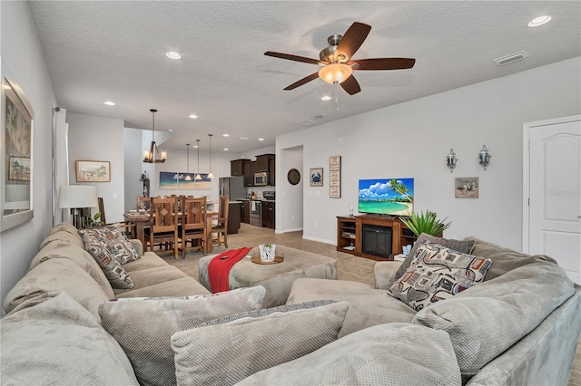 living room with ceiling fan and a textured ceiling