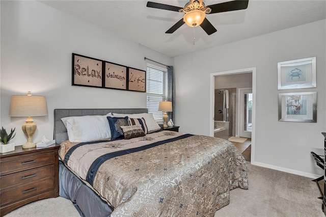 bedroom featuring ceiling fan, light colored carpet, and ensuite bathroom