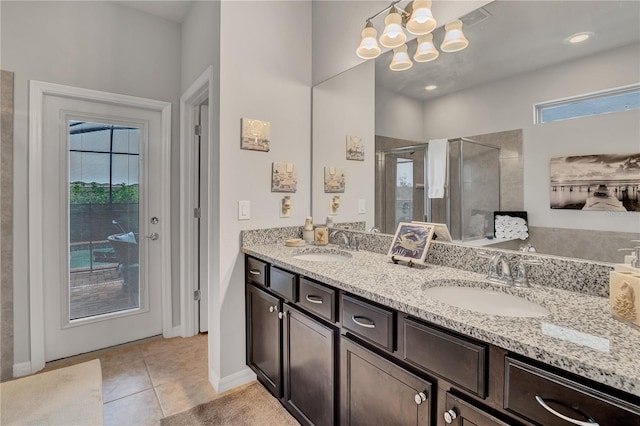 bathroom featuring vanity, an inviting chandelier, tile patterned floors, and an enclosed shower