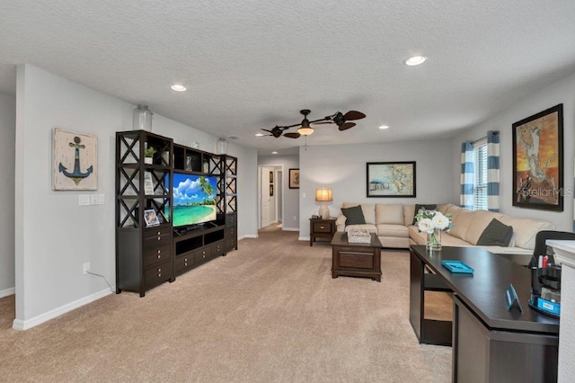 carpeted living room featuring ceiling fan and a textured ceiling