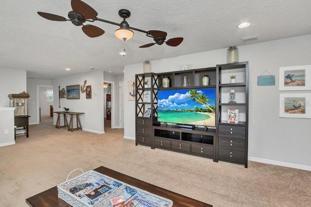 living room with a textured ceiling, carpet floors, and ceiling fan