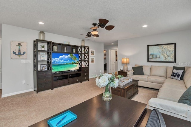 living room with light carpet, ceiling fan, and a textured ceiling