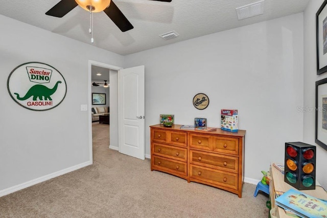 bedroom featuring a textured ceiling, ceiling fan, and light carpet